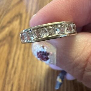 Sterling silver eternity band with princess cut clear stones.